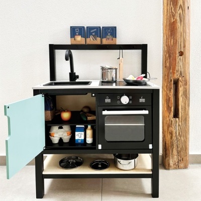 Cozinha de brincar preta com azul claro, pia, forno e acessórios visíveis.