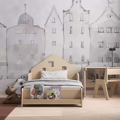 Quarto infantil com cama de madeira clara em forma de casa, mesa e cadeira combinando, parede com desenho de edifícios e brinquedo no chão