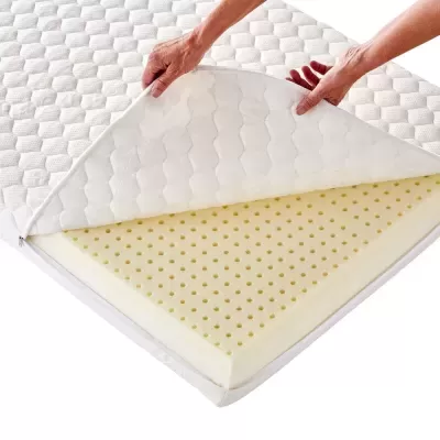 Colchão branco com capa acolchoada e espuma perfurada amarela visível