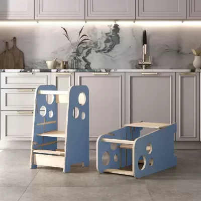 Duas mobílias infantis multifuncionais em madeira azul e natural numa cozinha moderna com armários brancos e bancada de mármore