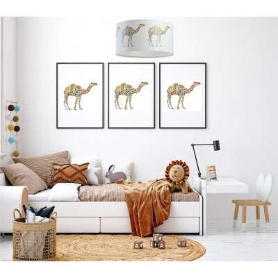 Quarto infantil com cama branca, manta castanha, peluche leão, três quadros com camelos, candeeiro com camelos, tapete bege, cadeira madeira e cesto vime.