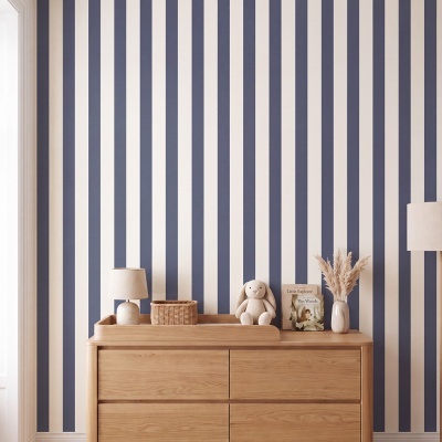 Cómoda de madeira clara com objetos decorativos contra parede de riscas verticais azul e branco