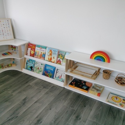 Móveis infantis em madeira clara com livros e brinquedos