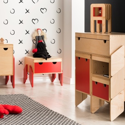 Mobiliário de madeira clara com detalhes vermelhos numa divisão com decoração de parede em preto