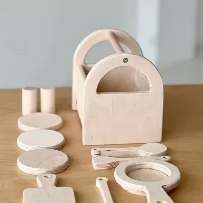 Utensílios de cozinha de madeira clara organizados sobre mesa