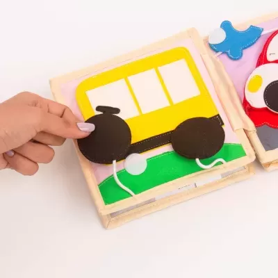 Livro infantil de tecido com autocarro amarelo e rodas pretas removíveis