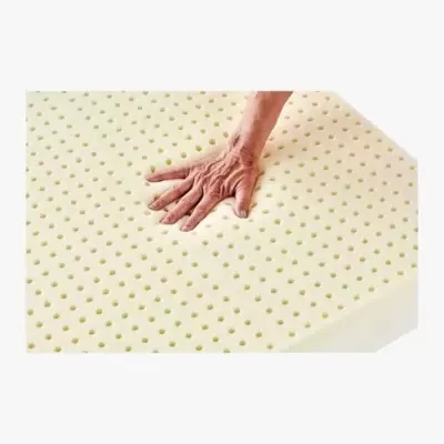 Colchão amarelo claro em espuma perfurada com mão pousada