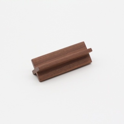 Peça de madeira castanha com entalhes sobre fundo branco