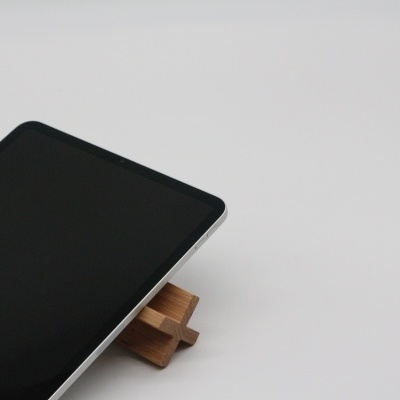 Smartphone com ecrã preto sobre base de madeira clara