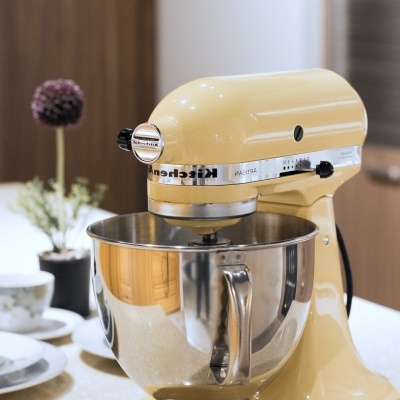 Robot de cozinha KitchenAid creme com taça metálica na cozinha