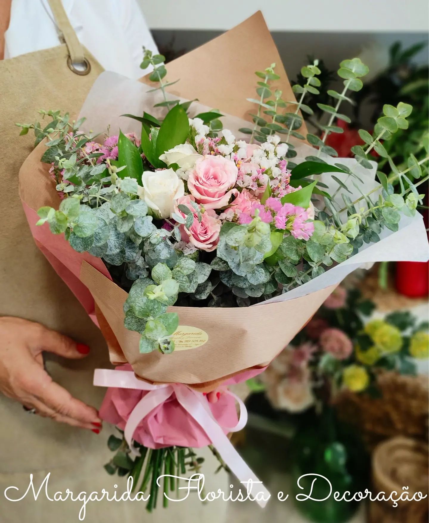 Buquê de flores com rosas e folhagem verde envolto em papel