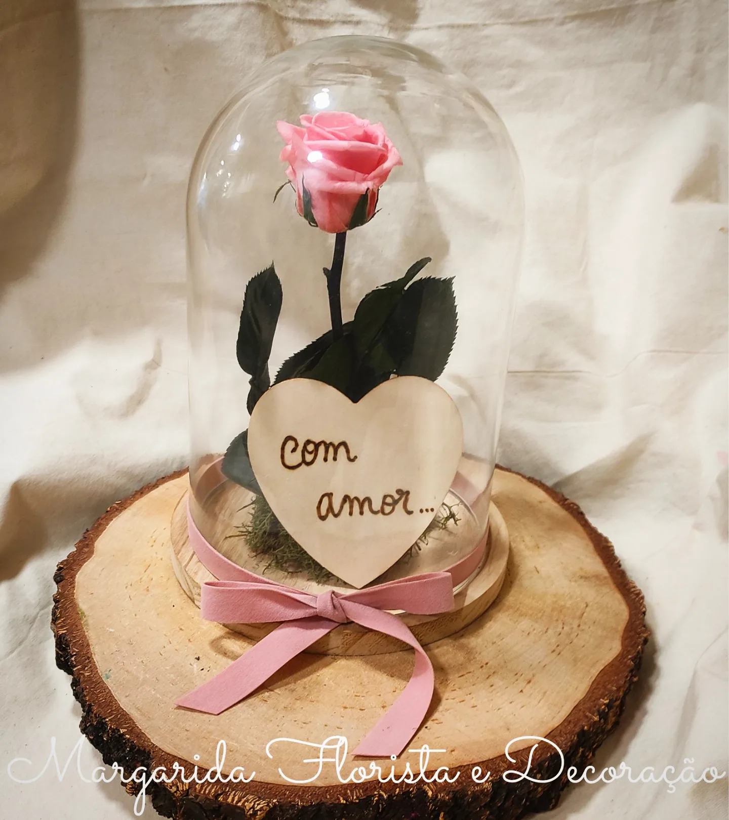 Rosa cor-de-rosa preservada em cúpula de vidro com decoração e texto