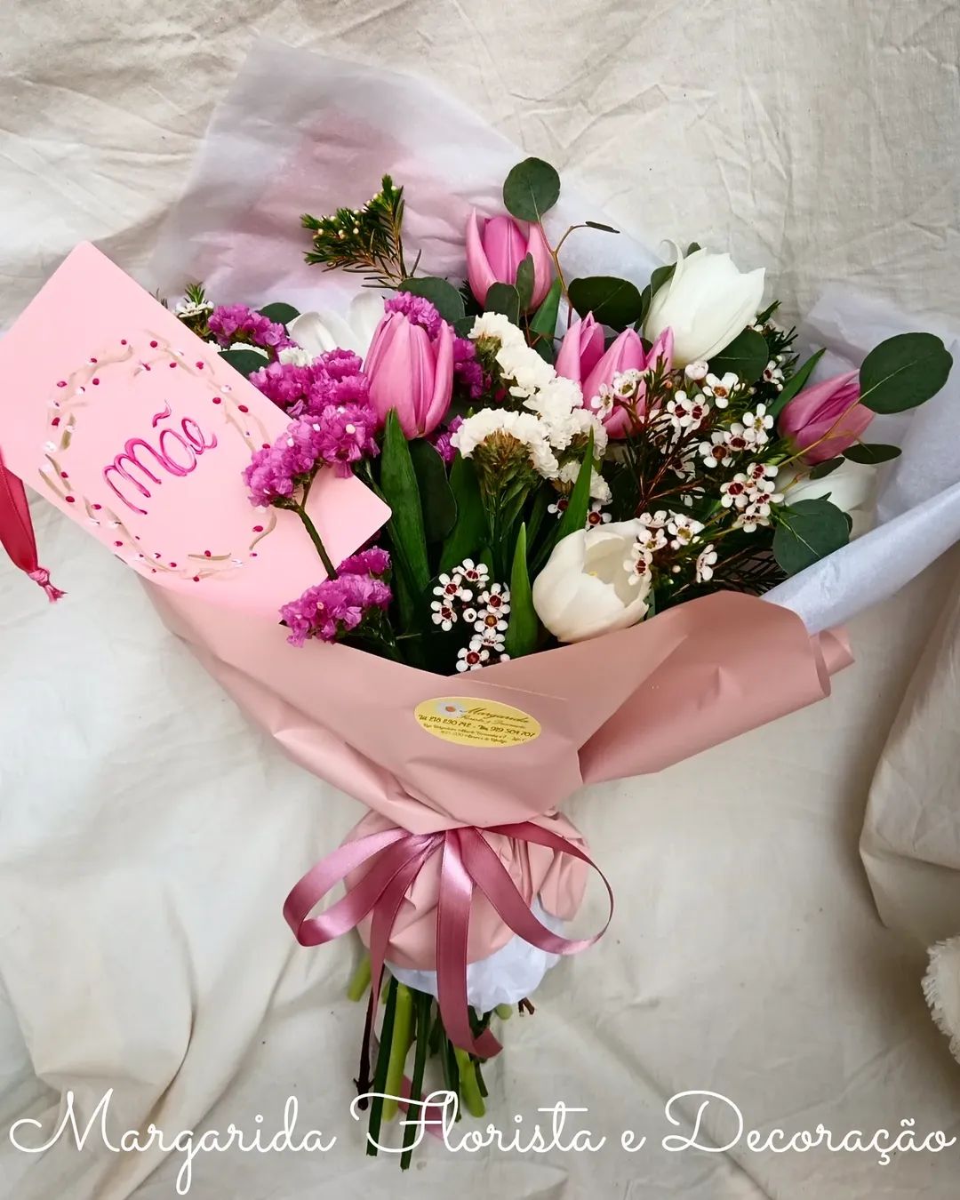 Buquê de flores com papel rosa e laço, cartão escrito Mãe