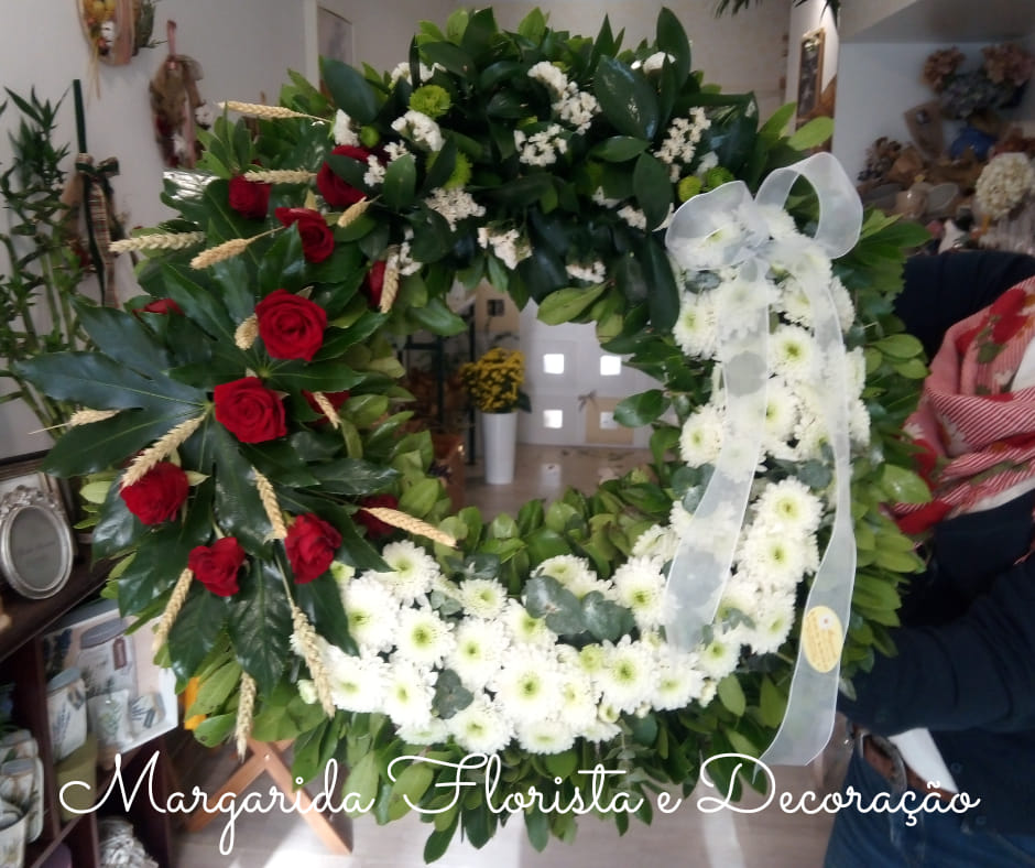 Coroa funerária floral com rosas vermelhas e crisântemos brancos numa loja de flores