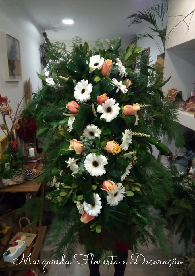 Arranjo floral cascata com flores brancas e pêssego e folhagem verde