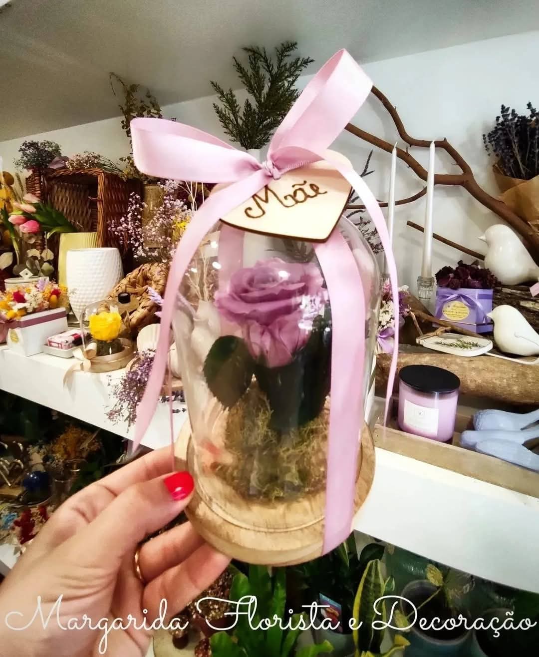 Arranjo floral com rosa lilás em cúpula de vidro e fita rosa