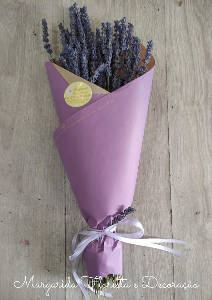 Buquê de lavanda embalado em papel roxo e bege, amarrado com fita branca