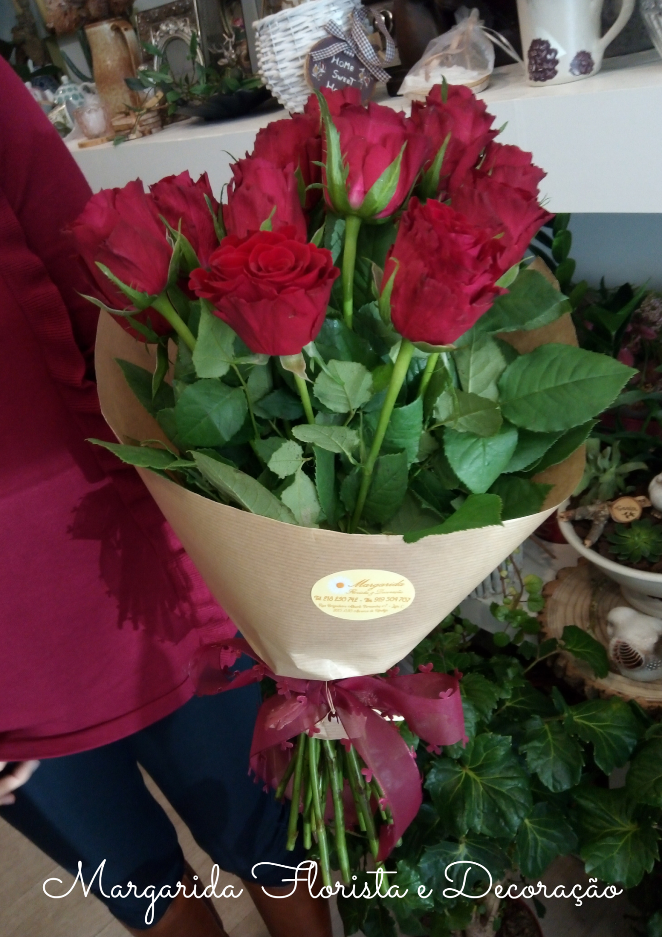 Bouquet de rosas vermelhas envolvido em papel kraft com laço vermelho numa florista