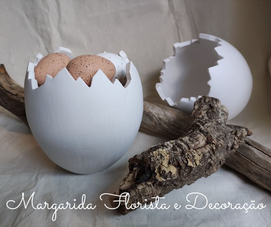 Casco de ovo branco com ovos castanhos e pedaço de madeira sobre tecido claro
