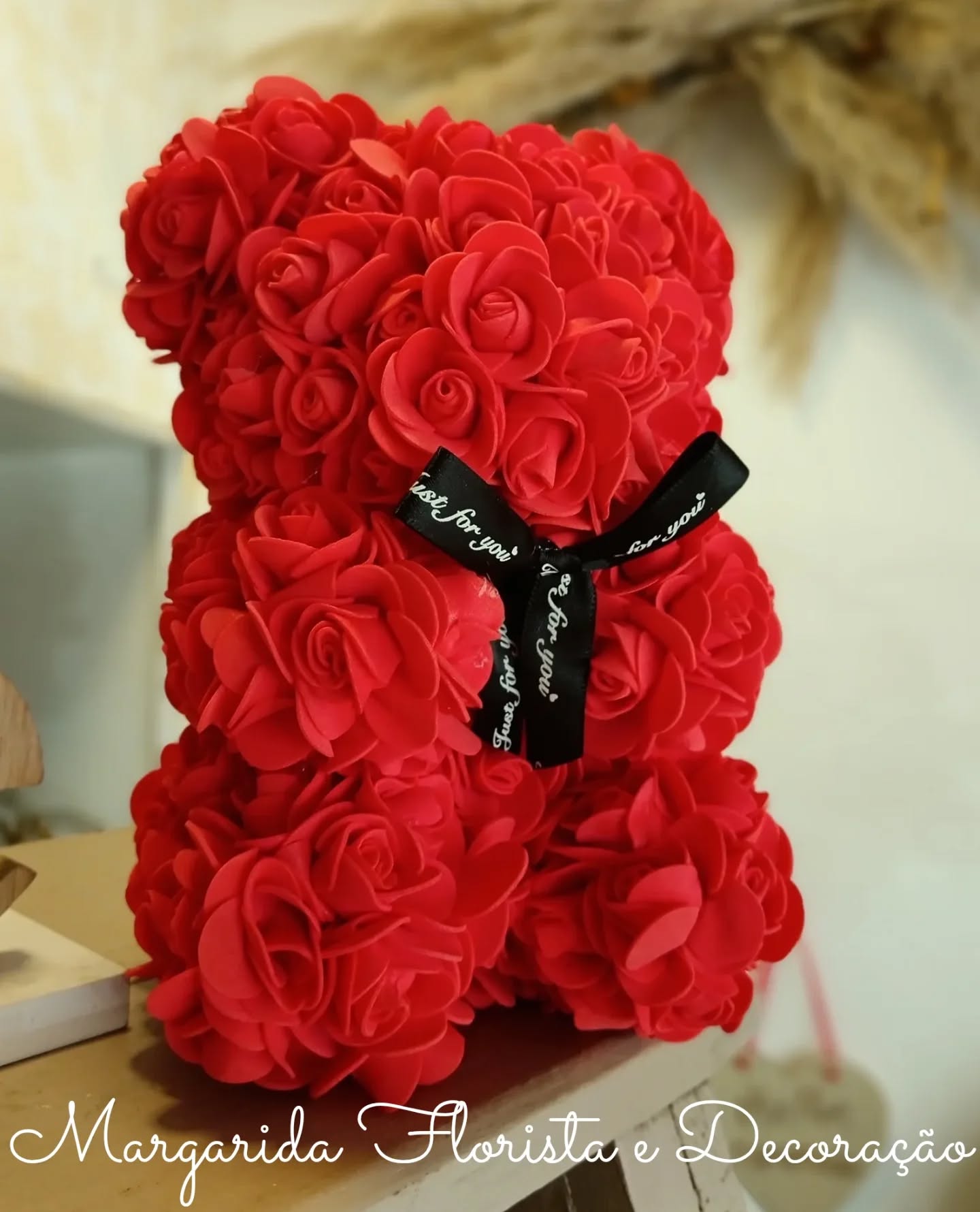 Urso de rosas artificiais vermelhas com laço preto