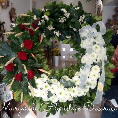 Coroa funerária floral com rosas vermelhas e crisântemos brancos numa loja de flores