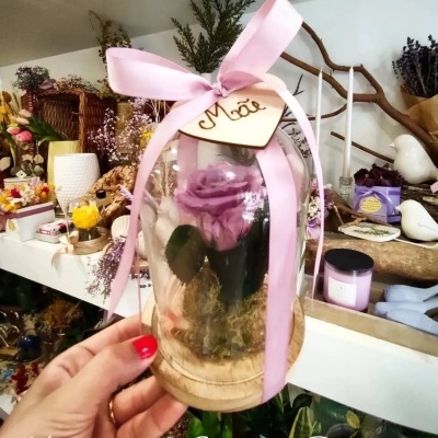 Arranjo floral com rosa lilás em cúpula de vidro e fita rosa