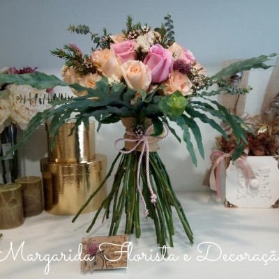 Bouquet de rosas manchadas rosas e pêssego com folhas verdes em decoração interior