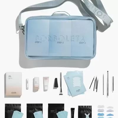 Kit de produtos Borboleta para skincare com bolsa azul clara e vários itens organizados ao redor