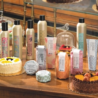 Mesa com produtos cosméticos variados e bolos decorativos em ambiente interno