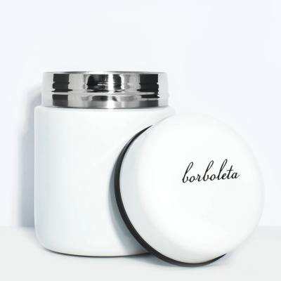 Frasco branco com tampa metálica prateada e outra tampa branca com texto 'borboleta'
