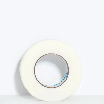 Rolo de fita adesiva branca sobre superfície branca