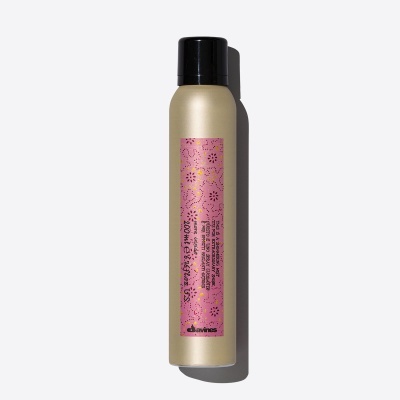 Frasco dourado com tampa preta e etiqueta rosa de spray