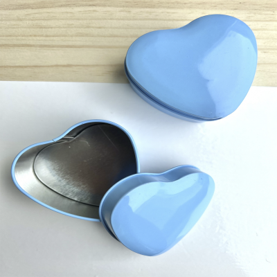 Duas caixas metálicas azuis em forma de coração, uma aberta e outra fechada