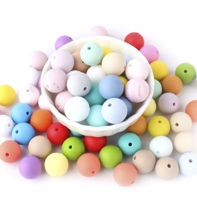 Contas redondas coloridas com furo dentro e fora de tigela branca