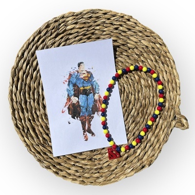 Colar colorido com cartão do Superman sobre base redonda de fibra trançada