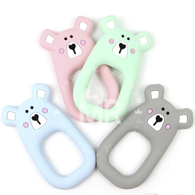 Quatro mordedores de silicone em forma de urso em cores pastel (rosa, verde, azul, cinza)
