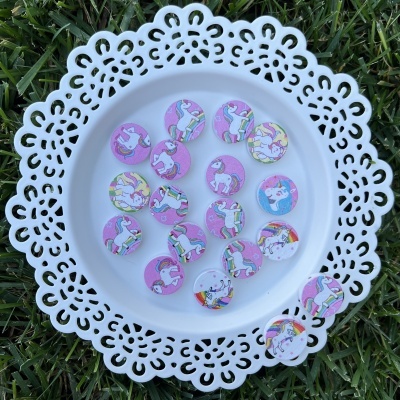 Placa branca decorativa com botons de unicórnios coloridos