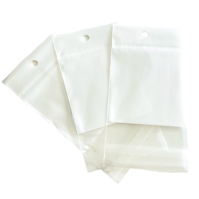 Sacos plásticos transparentes com parte superior opaca branca e furo circular para pendurar