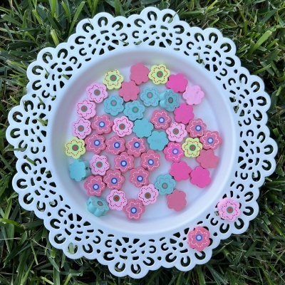 Prato branco com flores de madeira coloridas sobre relva