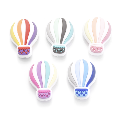 Brinquedos coloridos em forma de balão de ar quente com corações nos cestos