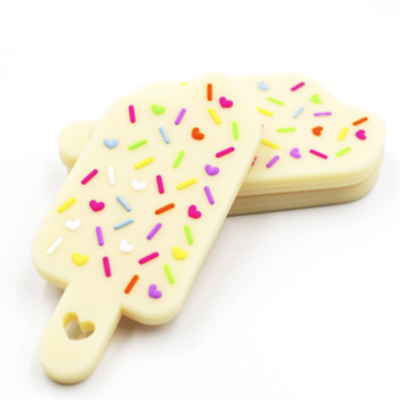 Biscoitos em forma de gelado com cobertura branca e confeitos coloridos