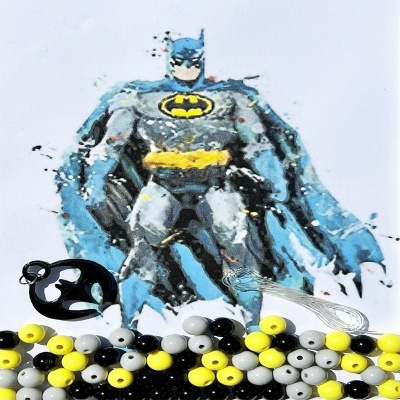 Figura do Batman impressa com contas plásticas coloridas no primeiro plano sobre fundo branco