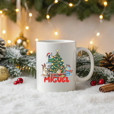 Caneca branca com desenho de personagens a decorar árvore de Natal e nome MIGUEL