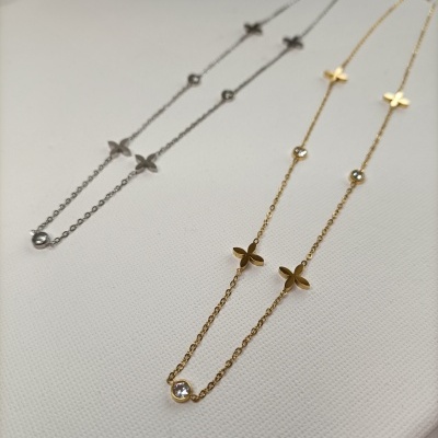 Colares finos prateado e dourado com flores e pedras em fundo branco