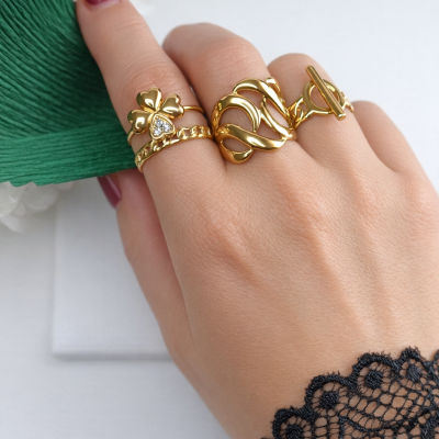 Mão feminina com anéis dourados e detalhe de renda preta