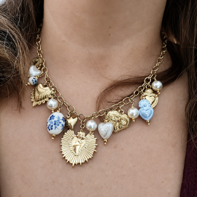 Colar dourado com pendentes de corações, pérolas e porcelana branca com padrão azul.