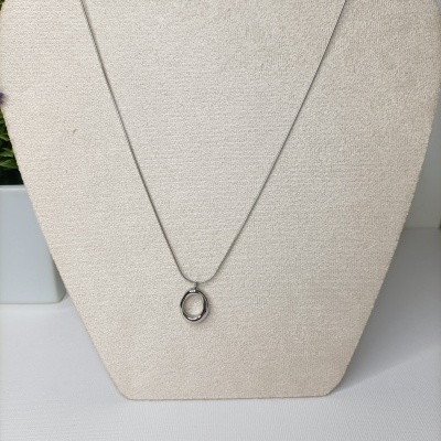 Colar prateado com pendente oval na base de tecido bege