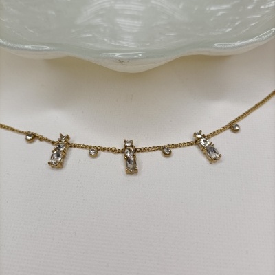 Colar dourado com pendentes de gatos e pedras transparentes