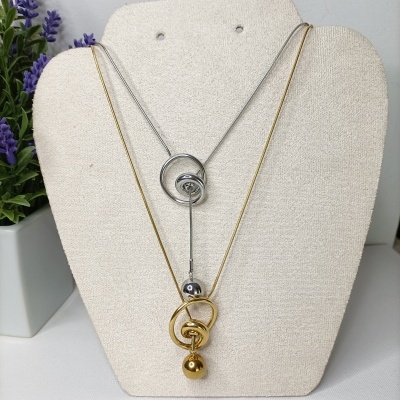 Colares dourado e prateado com pendentes esféricos em suporte bege