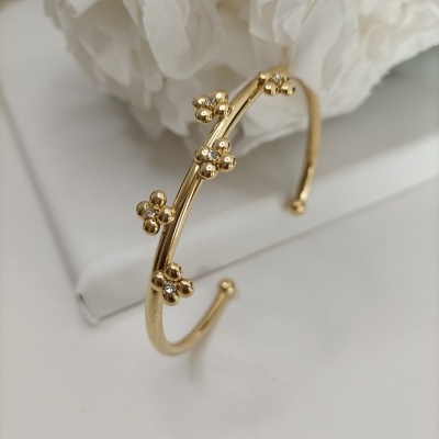 Pulseira dourada com flores pequenas e pedras brilhantes